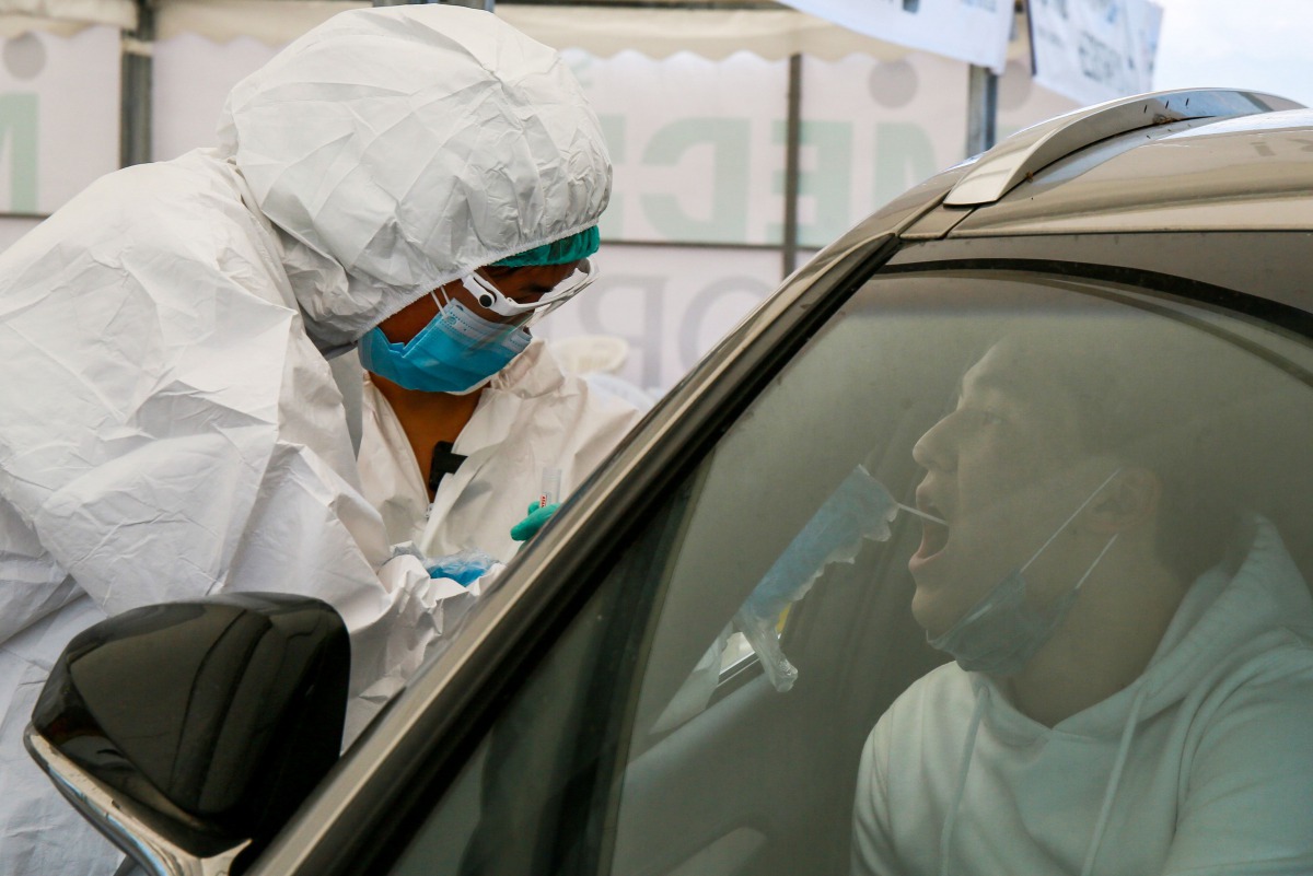 A healthcare worker gives a Covid-19 test to a medical staff near Halyk Arena in Almaty, on July 5, 2020 as Kazakhstan imposed a second round of nationwide restrictions to counter a huge surge in coronavirus cases since the previous lockdown that has over