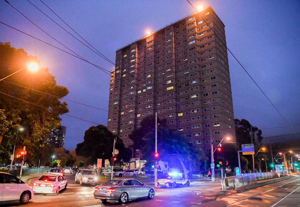 Police vehicles park outside one of nine public housing estates which have been locked down in Melbourne on July 4, 2020 with more than 3000 residents in 1,345 units required to stay home due to an outbreak of the COVID-19 coronavirus. / AFP / William WES