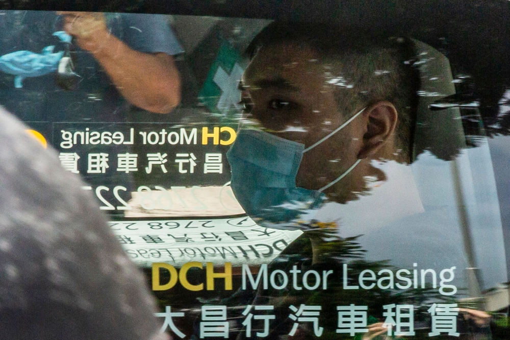 Tong Ying-kit, who is accused of deliberately driving his motorcycle into a group of police officers on July 1, arrives at the West Kowloon court in Hong Kong on July 6, 2020. AFP / ISAAC LAWRENCE
