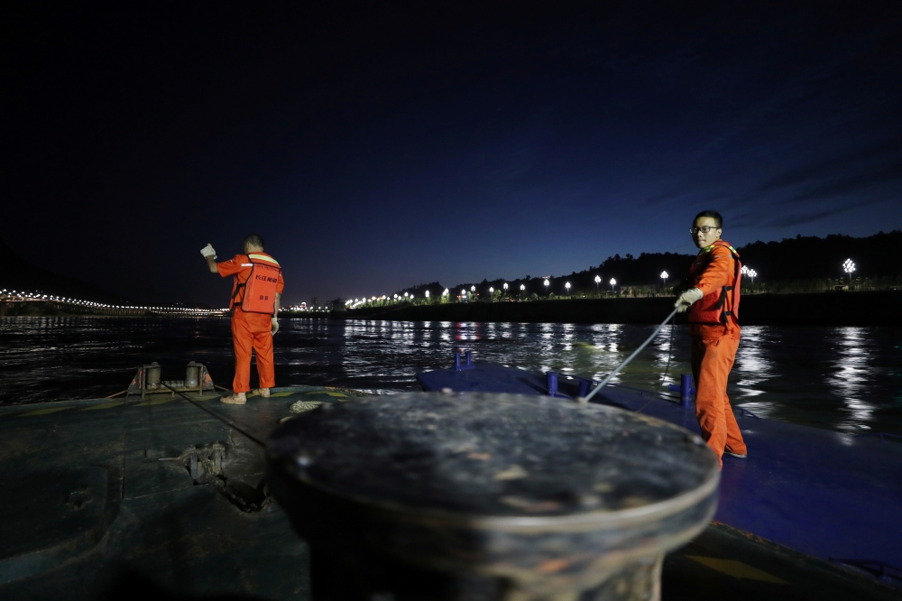 Workers of Yibin waterway bureau adjust a buoy on the Yibin section of the Yangtze River, whose water level has risen following heavy rainfall, in Yibin, Sichuan province, China July 2, 2020. Picture taken July 2, 2020. China Daily via Reuters 