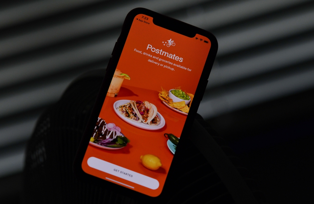 This file illustration photo taken on June 30, 2020 shows the logo of delivery app Postmates on a smartphone screen in Los Angeles. / AFP / Chris DELMAS
