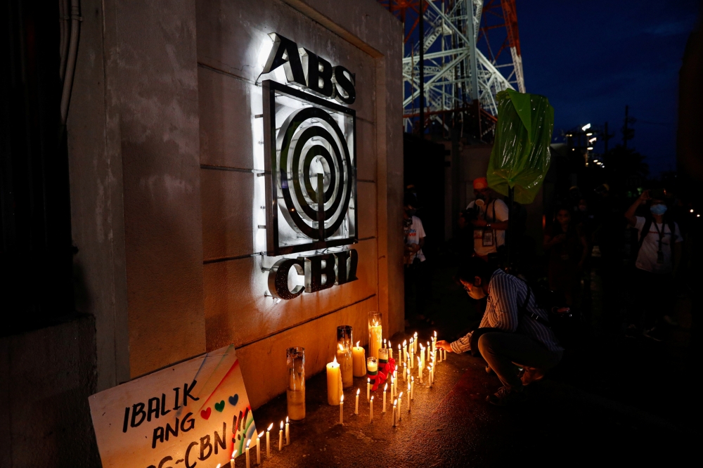 A journalist lights a candle outside the ABS-CBN headquarters, following Philippine congress' vote against the broadcast network's franchise renewal, in Quezon City, Metro Manila, Philippines, July 10, 2020. REUTERS/Eloisa Lopez