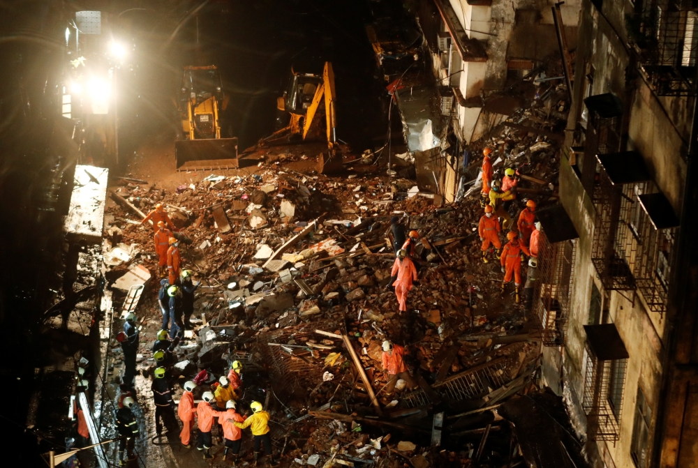 National Disaster Response Force (NDRF) and fire brigade personnel look for survivors trapped in the debris after part of a residential building collapsed following heavy rains in Mumbai, India, July 16, 2020. REUTERS/Francis Mascarenhas