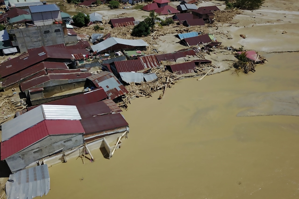 This aerial handout picture taken and released on July 17, 2020 by Indonesian mitigation management agency (BNPB) shows houses buried in mud in North Luwu, South Sulawesi, after several rivers burst their banks following torrential rains in the region./ A