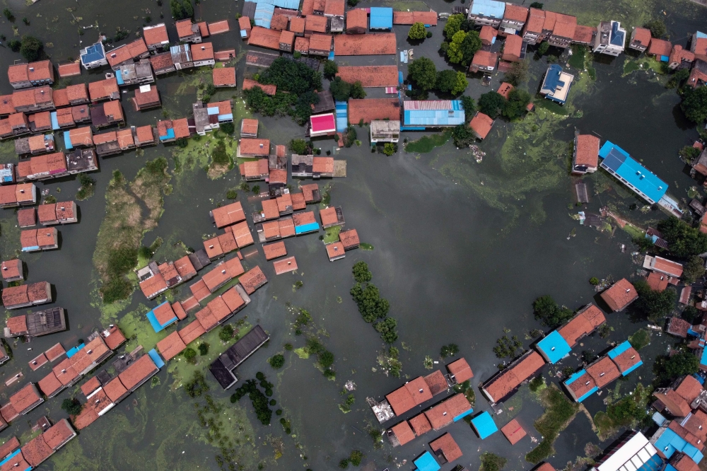 An aerial view shows flooded residential buildings due to rising water levels of the Yangtze river in Jiujiang, China's central Jiangxi province, on July 18, 2020. / AFP / Hector RETAMAL