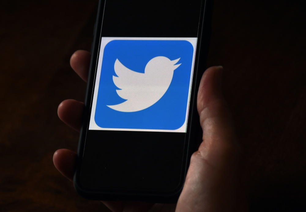 In this file photo illustration, a Twitter logo is displayed on a mobile phone on May 27, 2020, in Arlington, Virginia. Twitter says hackers 
