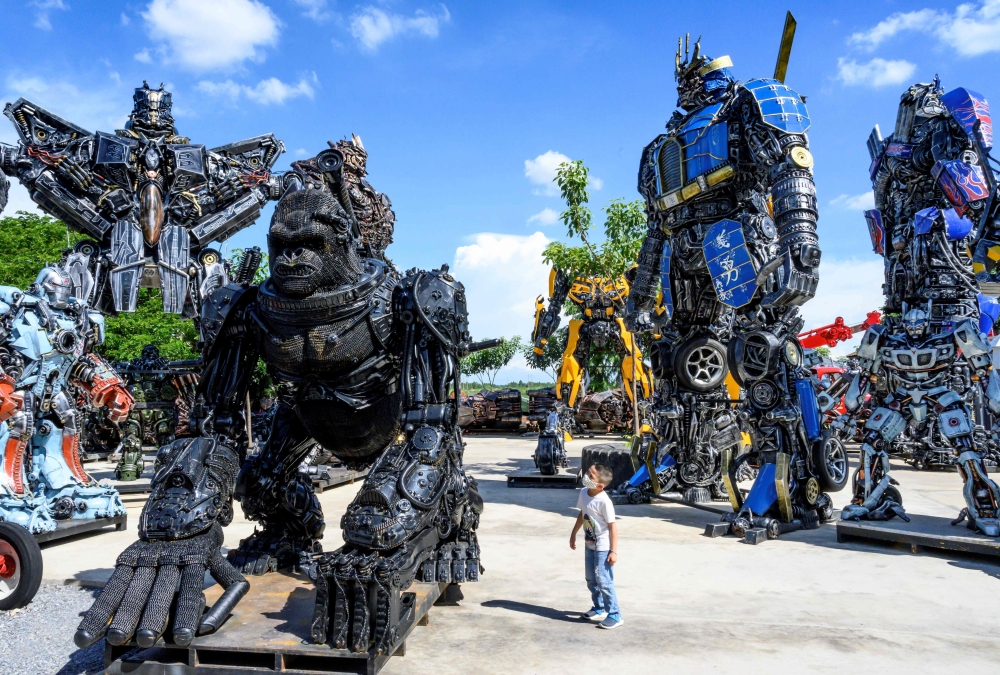 This photograph taken on July 18, 2020 shows a child looking at a figure of King Kong in front of life-sized sculptures of characters from the 