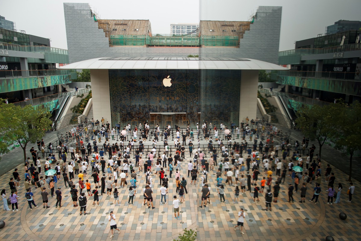 People observe social distancing as they wait for the opening of the new Apple flagship store following an outbreak of the coronavirus disease (COVID-19) in Sanlitun in Beijing, China, July 17, 2020. REUTERS/Thomas Peter