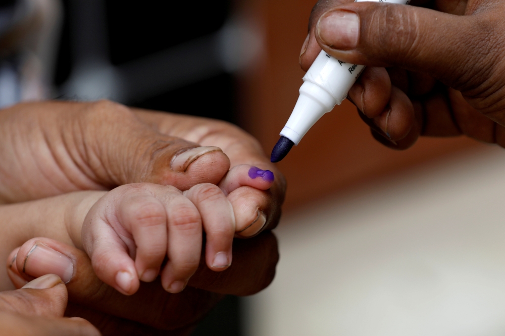 A boy gets his finger marked, after he is administered polio vaccine drops, during an anti-polio campaign, in a low-income neighbourhood as the spread of the coronavirus disease (COVID-19) continues, in Karachi, Pakistan July 20, 2020. REUTERS/Akhtar Soom