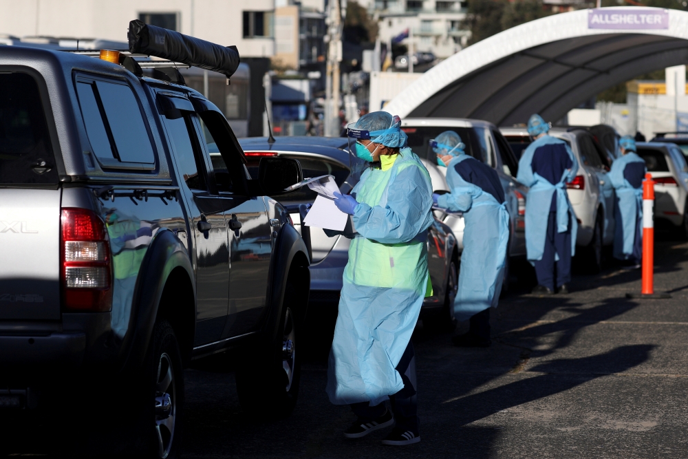 FILE PHOTO: Medical personnel administer tests for the coronavirus disease (COVID-19) at the Bondi Beach drive-through testing centre, as the state of New South Wales grapples with an outbreak of new cases, in Sydney, Australia, July 20, 2020. REUTERS/Lor