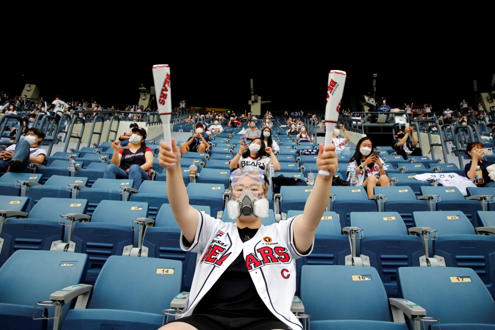 A fan wearing a face mask as a measure to avoid the spread of the coronavirus disease (COVID-19) cheers during a KBO baseball game between LG Twins and Doosan Bears at a baseball stadium in Seoul, South Korea, July 26, 2020. REUTERS/Heo Ran