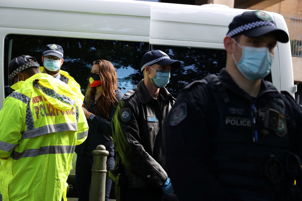 Police officers issue citation tickets to demonstrators, after police shut down a rally that was deemed unlawful, in Sydney, Australia, July 28, 2020. REUTERS/Loren Elliott