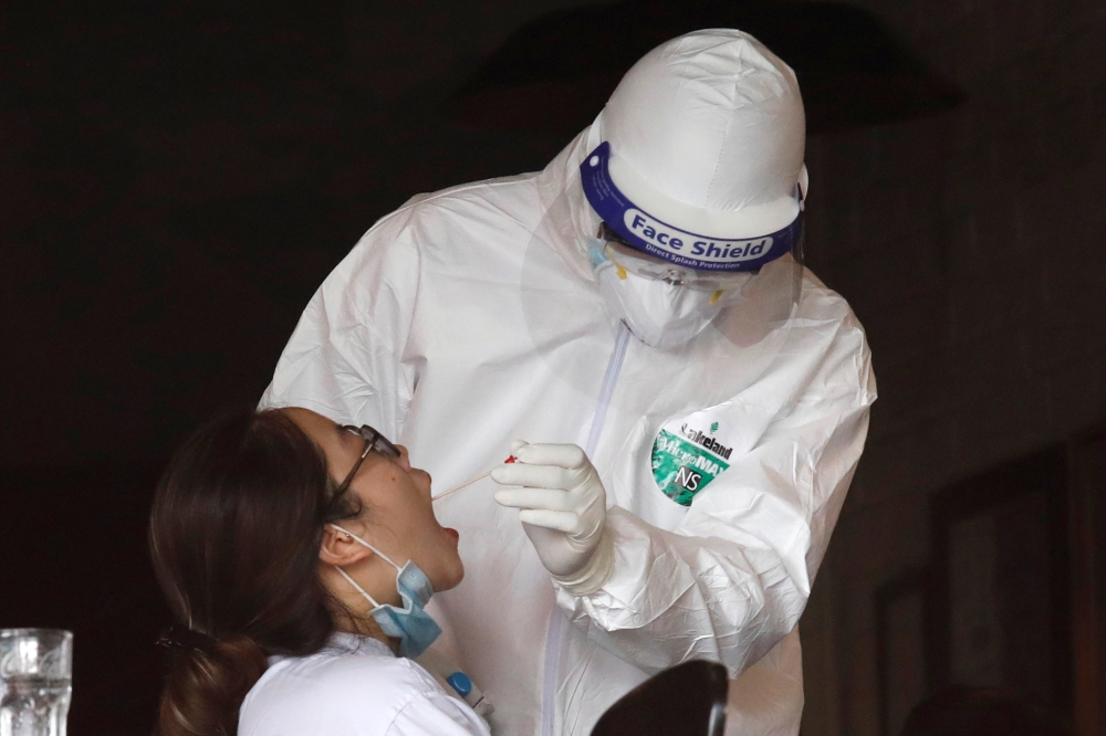 A health worker of Hanoi CDC gets test samples from an employee of a pizza restaurant where another employee tested positive with the coronavirus disease (COVID-19) after travel from Da Nang city, in Hanoi, Vietnam July 29, 2020. REUTERS/Kham