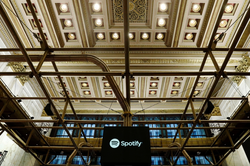 FILE PHOTO: The Spotify logo is displayed as the stock waits to begin selling as a direct listing on the floor of the New York Stock Exchange in New York, U.S., April 3, 2018. REUTERS/Lucas Jackson/File Photo