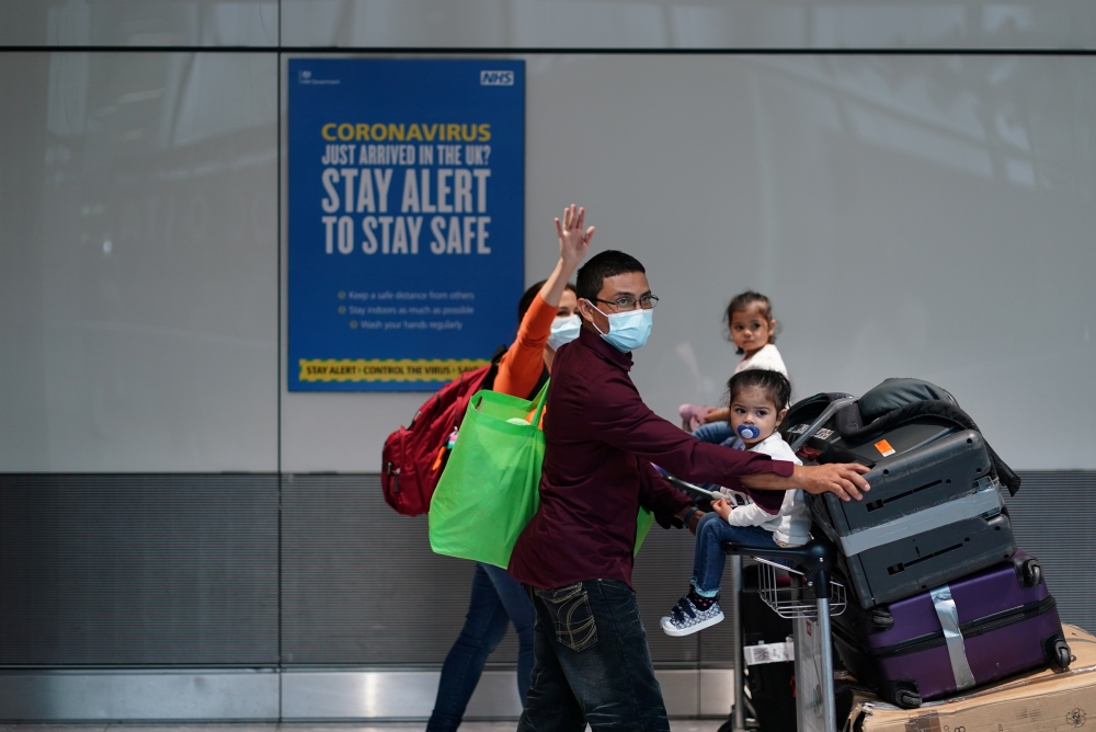 Travellers wearing face masks walk at the Terminal 5 at Heathrow Airport, as the spread of the?coronavirus?disease (COVID-19) continues, in London, Britain, July 26, 2020. REUTERS/Henry Nicholls