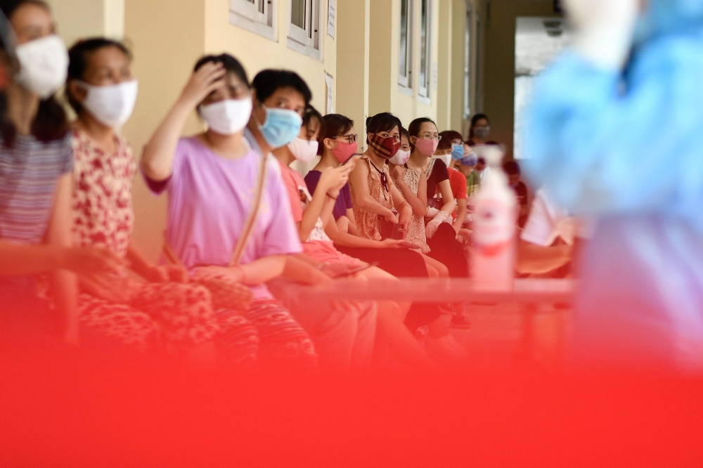 Residents wait to be tested at a makeshift rapid testing centre as Vietnam records a rise in cases of the COVID-19 coronavirus in Hanoi on July 31, 2020.  AFP / Manan VATSYAYANA
