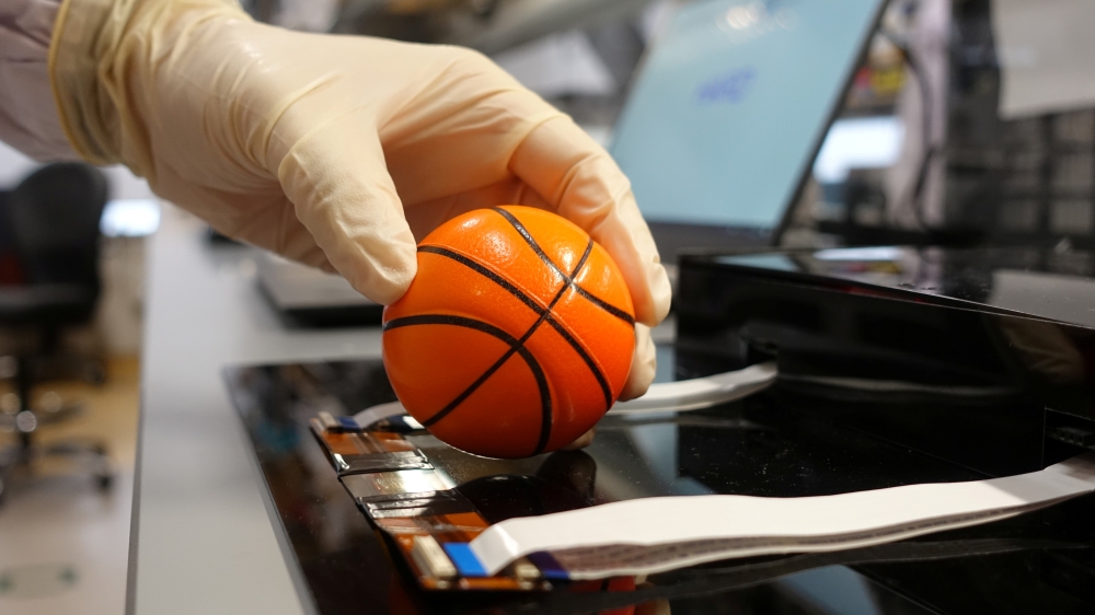 Dr. Benjamin Tee, Assistant Professor of Materials Science and Engineering at the National University of Singapore (NUS), demonstrates how his device can detect the texture of a soft stress ball at a lab in NUS, Singapore July 27, 2020. Picture taken July