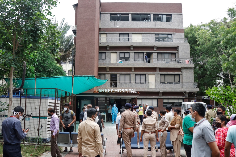Police officers and relatives stand outside a hospital where a fire broke out inside an intensive Care Unit (ICU) treating patients infected with the coronavirus disease (COVID-19) in Ahmedabad, India, August 6, 2020. REUTERS/Stringer 