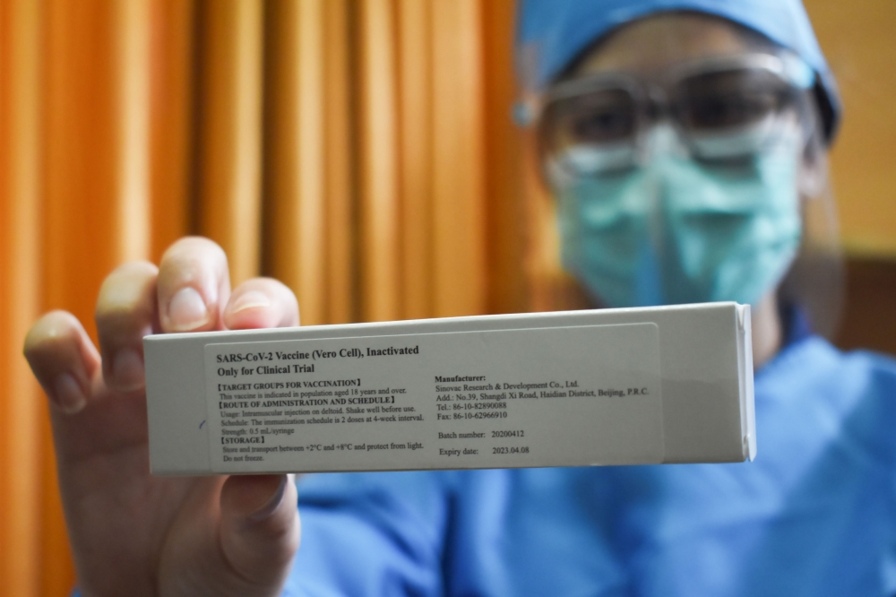 A doctor displays a vaccine for COVID-19 coronavirus at Padjadjaran university educational hospital in Bandung, West Java on July 6, 2020, in preparation for efforts to vaccinate 1,620 volunteers in the community next week. / AFP / TIMUR MATAHARI