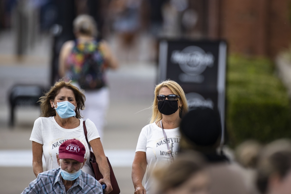 NASHVILLE, TN - AUGUST 03: Visitors to Lower Broadway, some wearing masks, walk between businesses on August 3, 2020 in Nashville, Tennessee. The number of coronavirus cases across the state has expanded rapidly in the last month. Brett Carlsen/Getty Imag