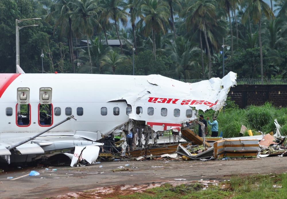Officials inspect the site where a passenger plane crashed when it overshot the runway at the Calicut International Airport in Karipur, in the southern state of Kerala, India, August 8, 2020. REUTERS/Stringer