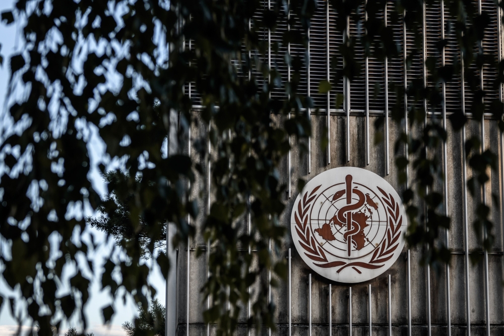 A photo taken in the late hours of August 17, 2020 shows a sign of the World Health Organization (WHO) at their headquarters in Geneva amid the COVID-19 outbreak, caused by the novel coronavirus. / AFP / Fabrice COFFRINI