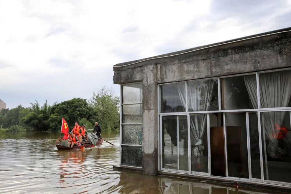 Community workers and volunteers deliver food and supplies to flood-affected residents after heavy rains in Neijiang in China's southwestern Sichuan province on August 19, 2020. China OUT / AFP / STR