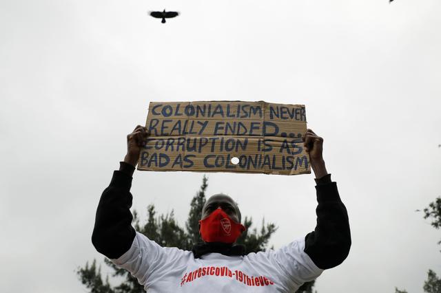 A protester holds a placard during a demonstration against suspected corruption in the response of the Kenyan government to the coronavirus disease (COVID-19) outbreak, in Nairobi, Kenya, August 21, 2020. REUTERS/Baz Ratner