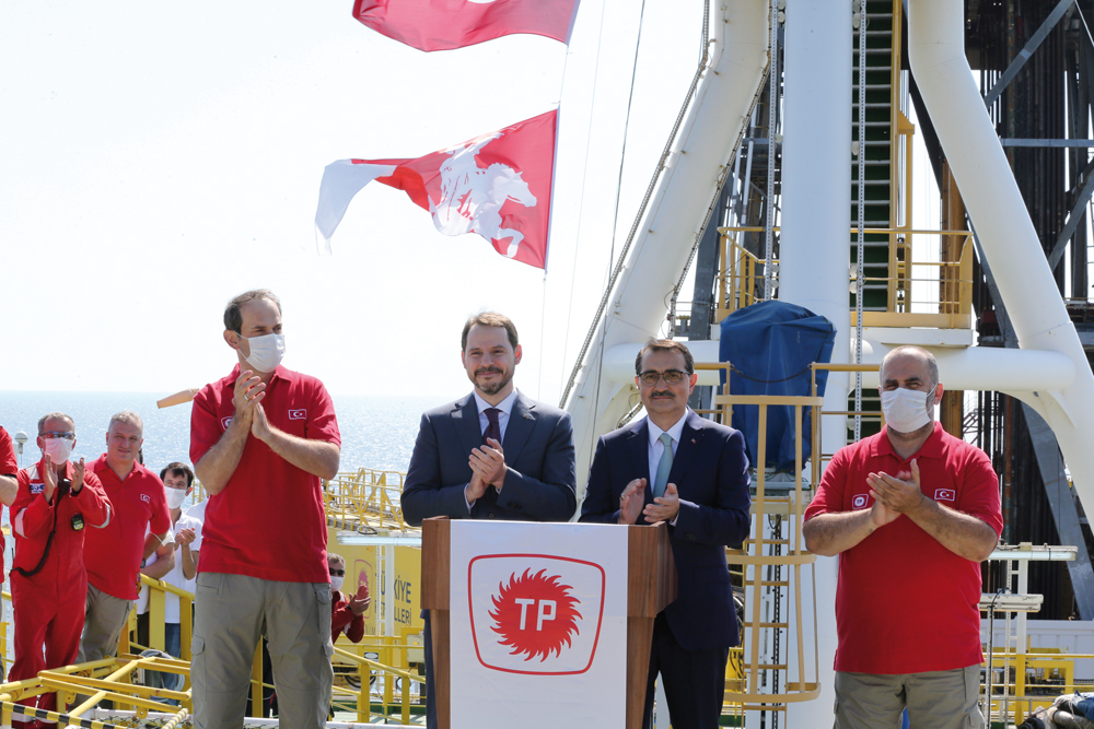 Turkish Finance Minister Berat Albayrak and Energy Minister Fatih Donmez applaud on the deck of drilling vessel Fatih in the western Black Sea, off Turkey, yesterday.