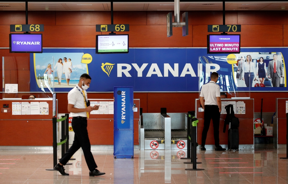 A man stands at a Ryanair check-in desk at Josep Tarradellas Barcelona-El Prat airport, amid the spread of the coronavirus disease (COVID-19), in Barcelona, Spain, July 26, 2020. REUTERS/Albert Gea/File Photo