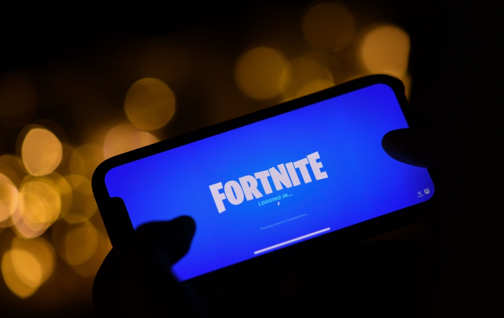 This file illustration photo taken on August 14, 2020 shows a person logging into Epic Games' Fortnite on their smartphone in Los Angeles. / AFP / Chris DELMAS