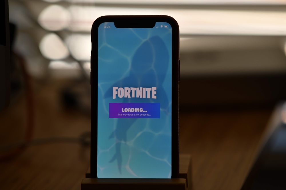 This file illustration photo taken on August 14, 2020 shows Epic Games' Fortnite loading on a smartphone in Los Angeles on August 14, 2020.  / AFP / Chris DELMAS