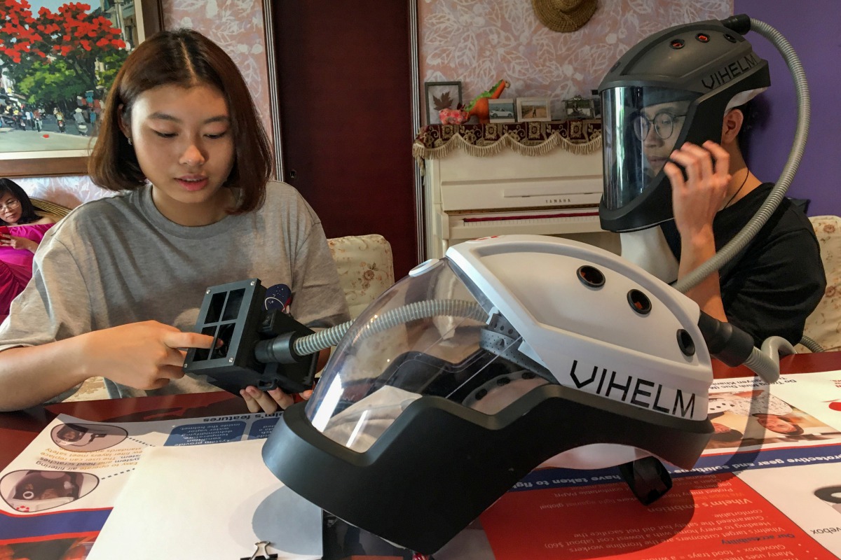 Students Tran Nguyen Khanh An, 14, and Do Trong Minh Duc, 16, work at home with a prototype helmet named Vihelm, which they designed to protect nurses and doctors from contracting the coronavirus disease (COVID-19) at hospitals, in Hanoi, Vietnam Septembe
