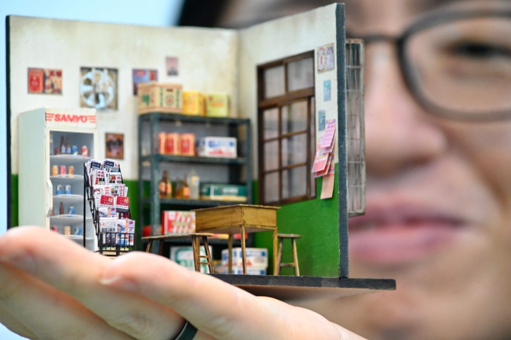 In this picture taken on August 5, 2020, miniature model artist Chen Shih-jen poses for a photograph with his work during an interview at FM Dioramas in Taoyuan, northern Taiwan. AFP / Sam Yeh 