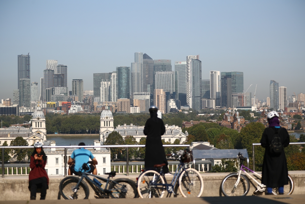 A skyline of the Canary Wharf financial district is seen as people enjoy the weather in London, Britain September 14, 2020. REUTERS/Hannah McKay