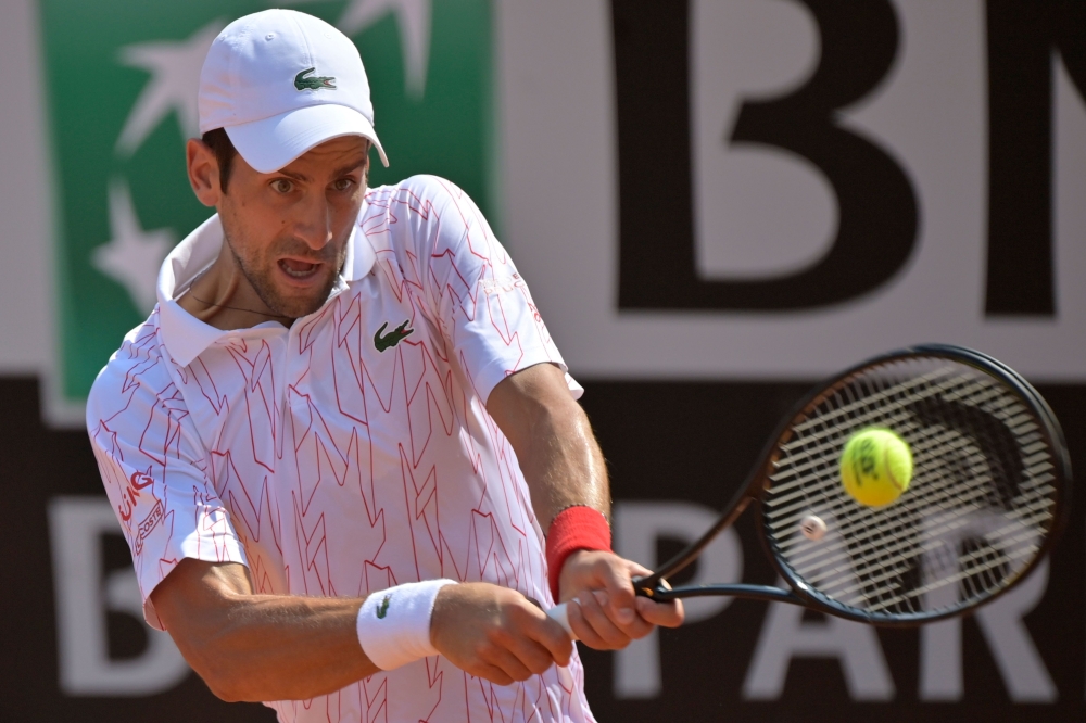 Serbia's Novak Djokovic plays a backhand to Italy's Salvatore Caruso on day three of the Men's Italian Open at Foro Italico on September 16, 2020 in Rome, Italy. / AFP / POOL / Riccardo Antimiani