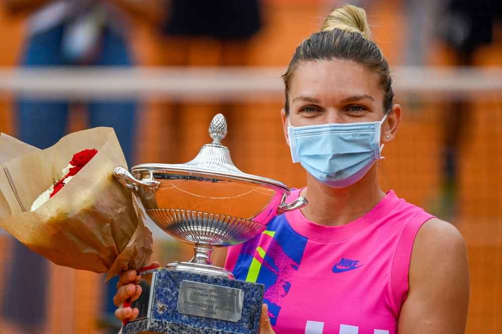 Romania's Simona Halep holds her trophy after winning the final match of the Women's Italian Open against Czech Republic's Karolina Pliskova, who pulled out following injury, at Foro Italico on September 21, 2020 in Rome, Italy. / AFP / POOL / Riccardo An