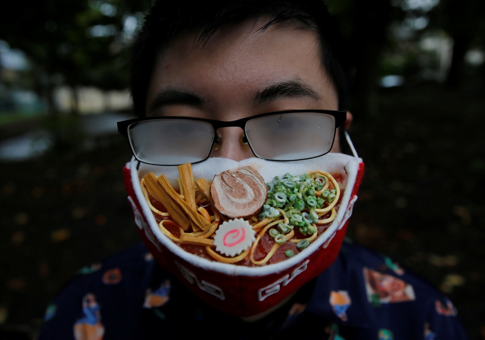 Japanese designer Takahiro Shibata's glasses fog up as he wears a protective mask that looks like a steaming bowl of ramen noodle soup while posing for a photo at a park, following the coronavirus disease (COVID-19) outbreak in Yokohama, Japan September 2