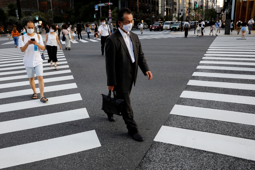 FILE PHOTO: People wearing protective masks make their way amid the coronavirus disease (COVID-19) pandemic at a business district in Tokyo, Japan August 4, 2020. REUTERS/Kim Kyung-Hoon/File Photo 