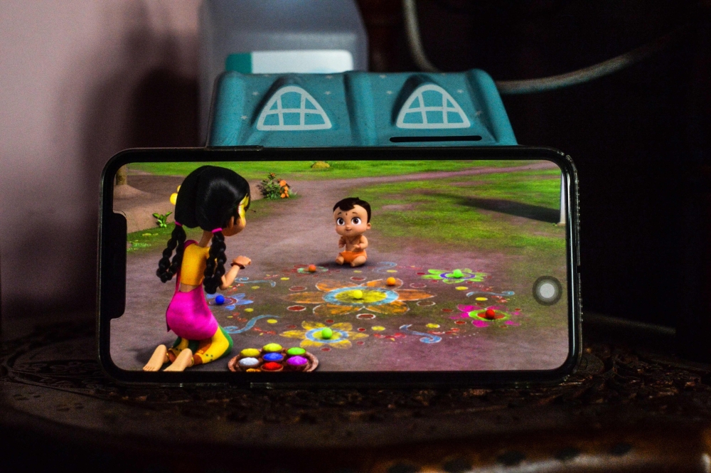 In this photo taken on October 7, 2020, a child watches 'Mighty Little Bheem' cartoon series on a mobile phone at home in New Delhi. It was a quest worthy of a superhero.  Ammu KANNAMPILLY / AFP / Sajjad HUSSAIN