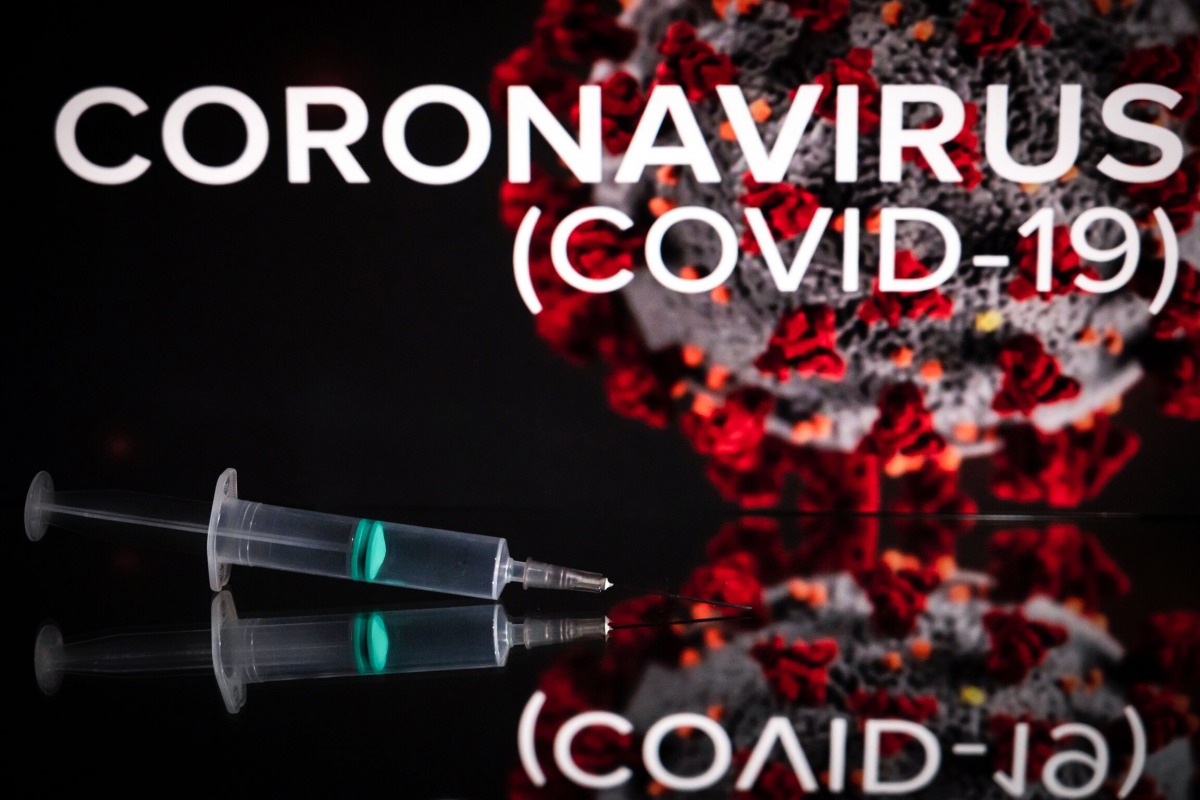 This photograph taken on October 7, 2020 shows a syringe on an illustration representing Covid-19 (novel coronavirus), in Toulouse, southwestern France. / AFP / Lionel BONAVENTURE
