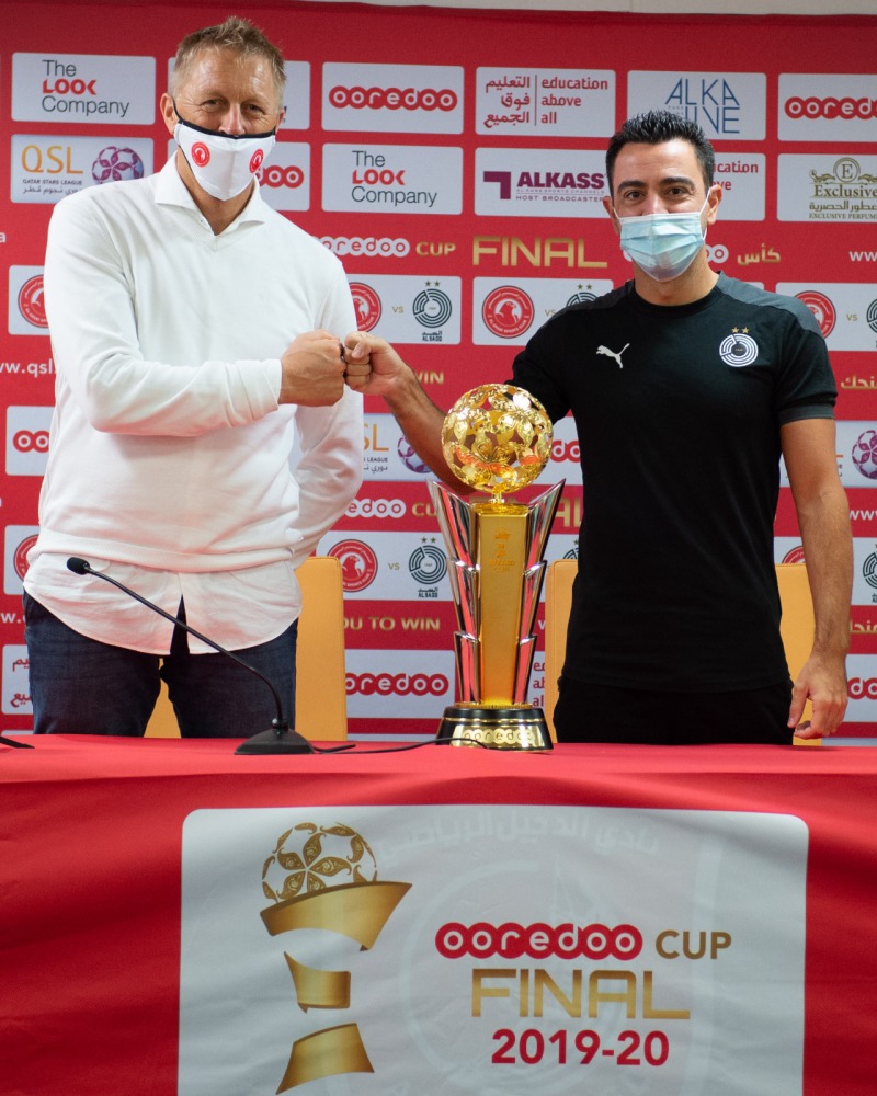 Al Sadd coach Xavi Hernandez (right) and Al Arabi coach Heimir Hallgrímsson pose with the Ooredoo Cup trophy during a press conference in Doha, yesterday. 