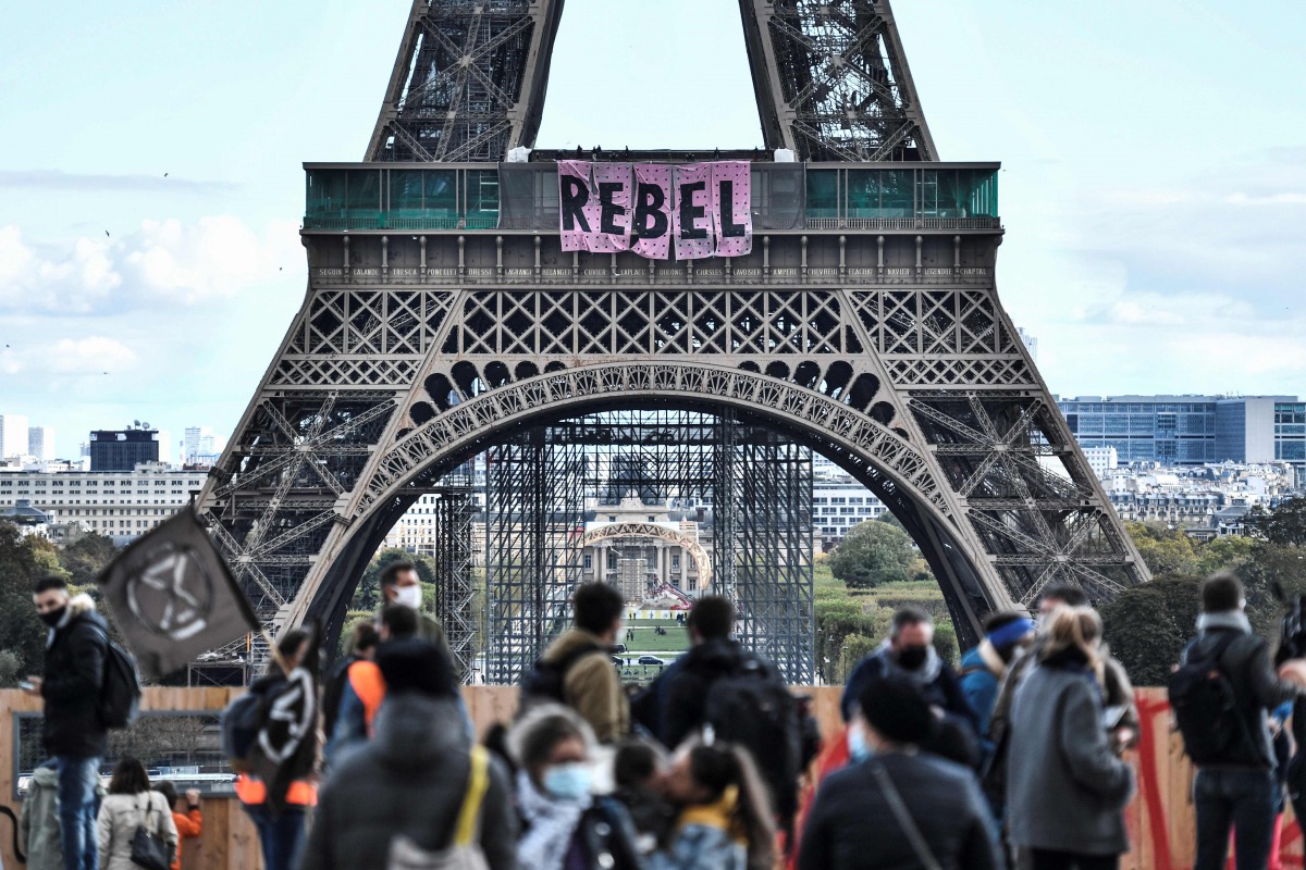 Activists of environmental protest group Extinction Rebellion (XR) deploy banners to read 