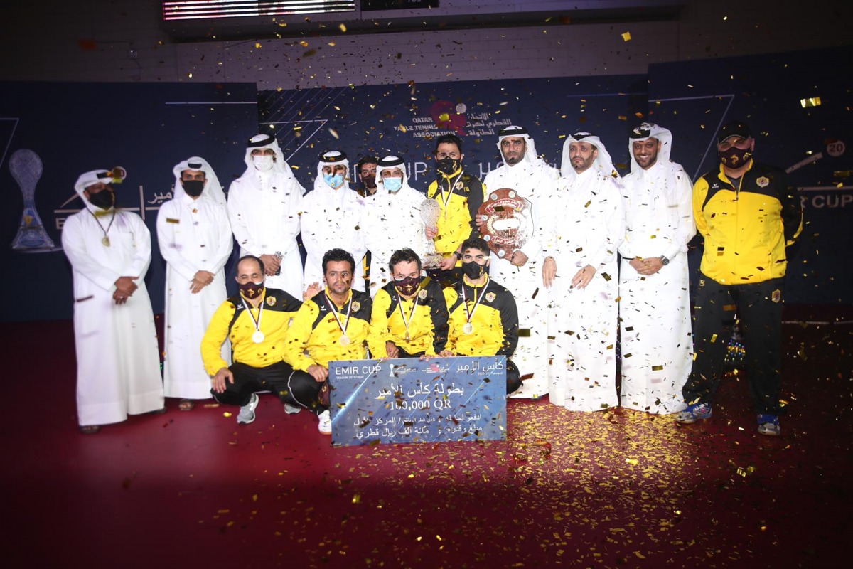 Qatar SC players and officials pose with the Amir Cup Table Tennis Championship trophy after winning the final against Al Sadd, yesterday.   
