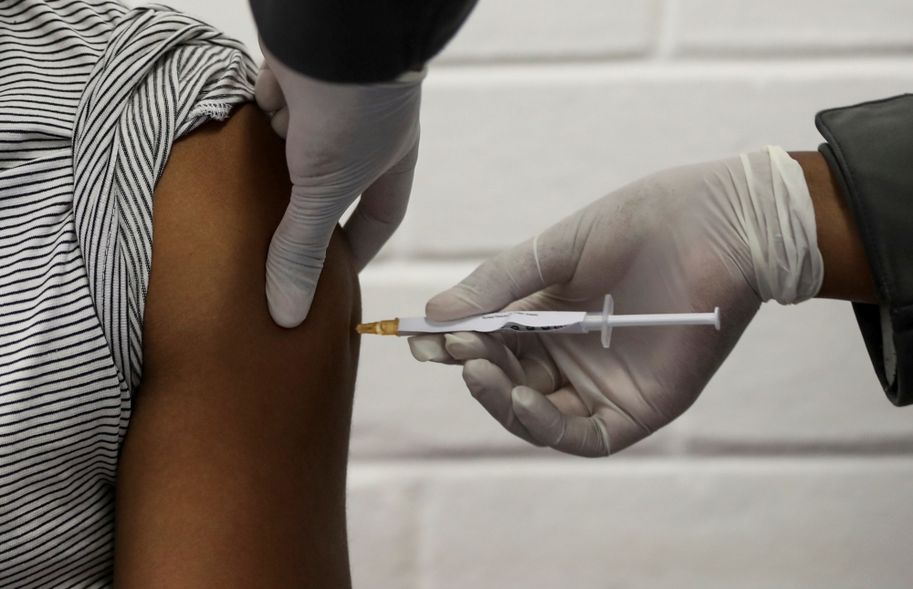 A volunteer receives an injection from a medical worker during the country's first human clinical trial for a potential vaccine against the novel coronavirus, at the Baragwanath hospital in Soweto, South Africa, June 24, 2020. REUTERS/Siphiwe Sibeko/File 