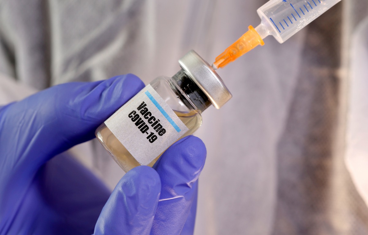 FILE PHOTO: A woman holds a small bottle labeled with a 