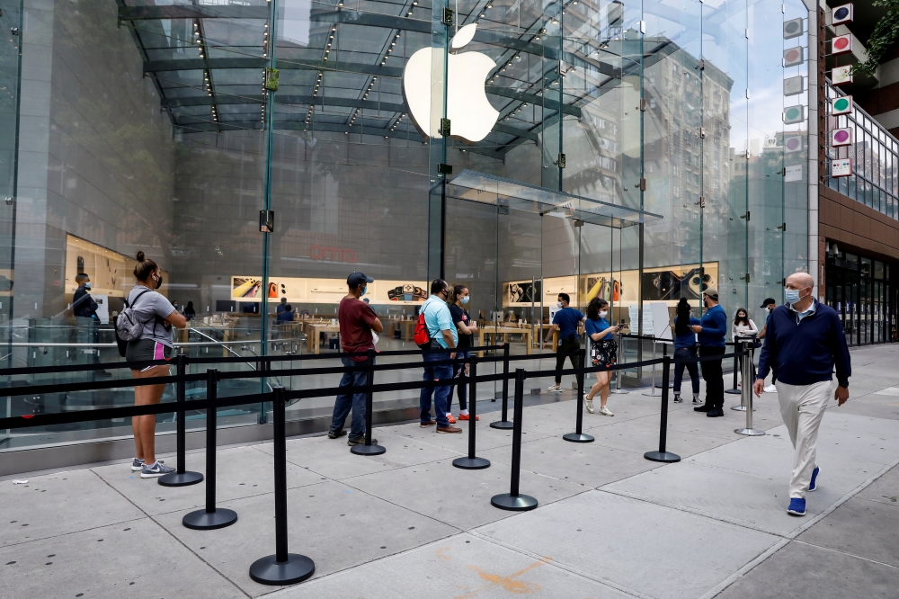 Customers distance before entering an Apple Store during phase one of reopening after the COVID-19 lockdown in New York City, New York, U.S. June 17, 2020. REUTERS/Brendan McDermid/File Photo