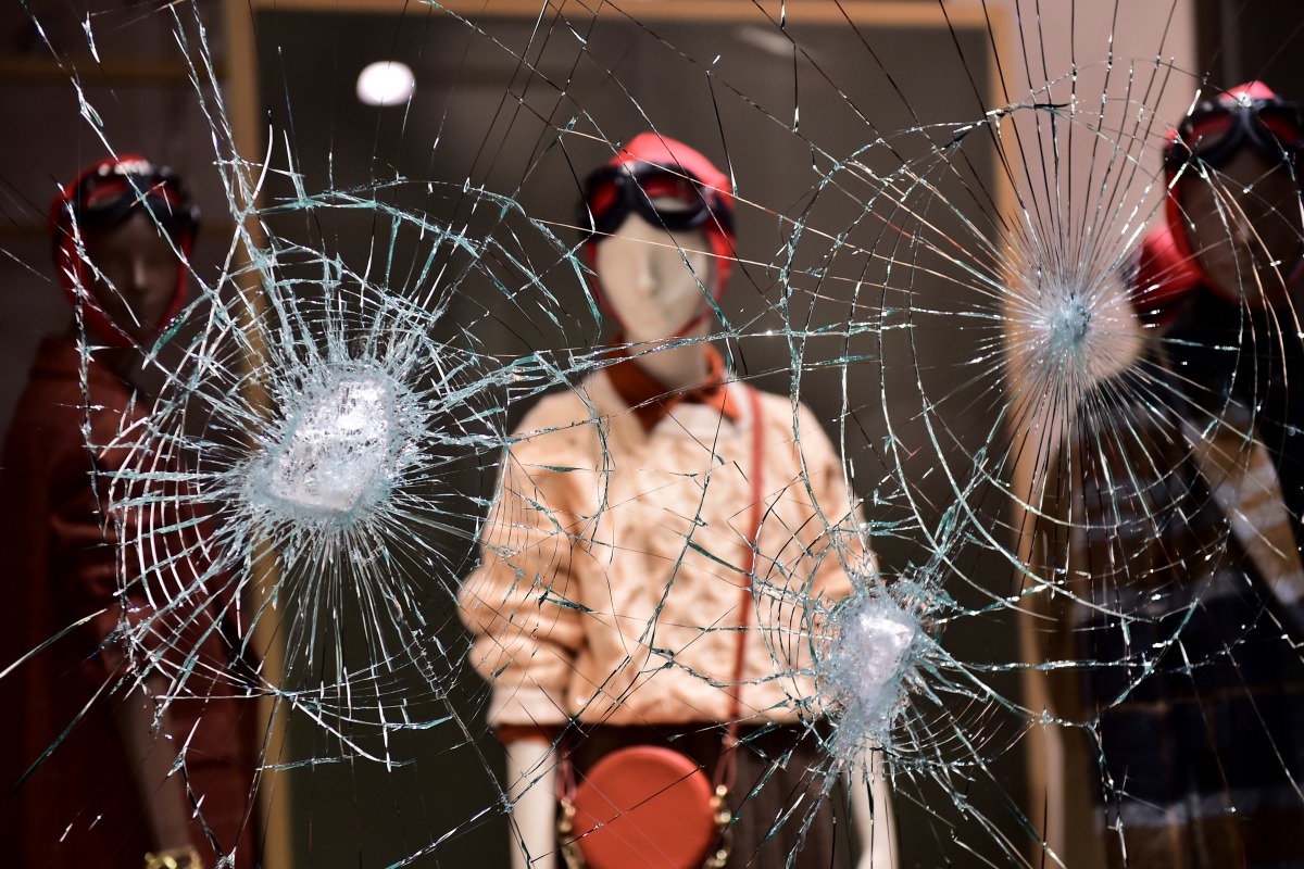 A damaged window of a store is seen as people protest against the new restrictions introduced by the government to curb the coronavirus disease (COVID-19) infections, in Turin, Italy, October 26, 2020. REUTERS/Massimo Pinca TPX IMAGES OF THE DAY

