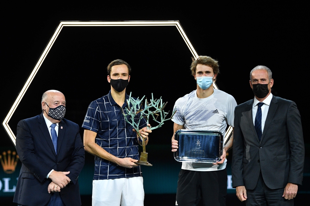 Russia's Daniil Medvedev (2nd L), flanked by President of the French Tennis Federation (FFT) Bernard Giudicelli (L) and Director of the Paris Masters tournament Guy Forget (R), celebrates with the trophy after winning his men's singles final tennis match 