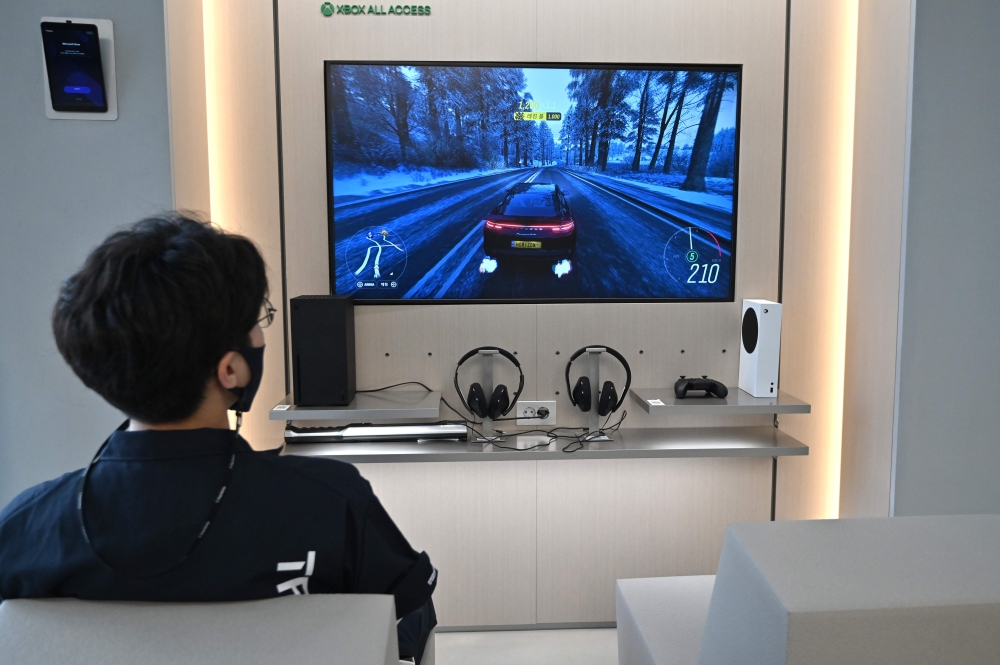 A staff member plays on Microsoft's Xbox Series X gaming console at a flagship store of SK Telecom in Seoul on November 10, 2020. / AFP / Jung Yeon-je
